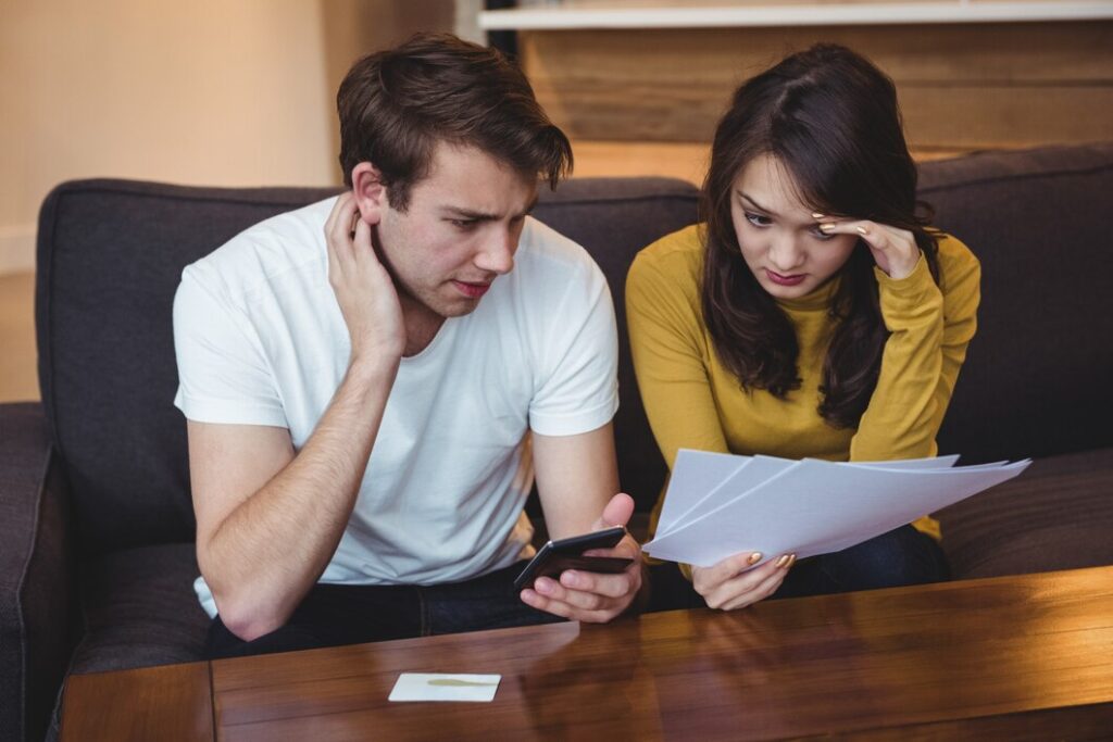 couple-sitting-sofa-discussing-with-financial-documents-living-room_107420-84892