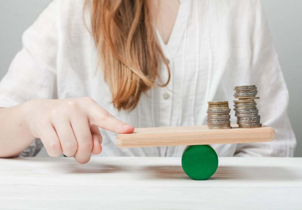 woman-holding-her-finger-balance-with-coins_23-2148546835